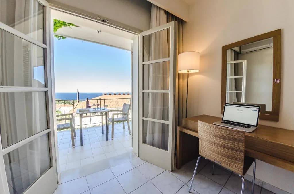 Studio interior with balcony doors open to the sea